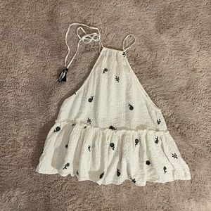 White tank top with embroidered design on it